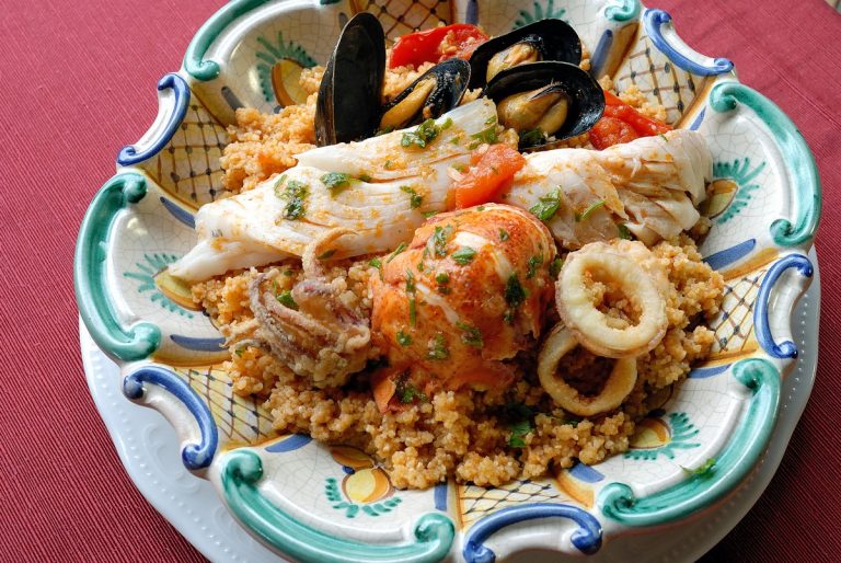 Cous cous di pesce con cozze, gamberi e calamari in ciotola decorata