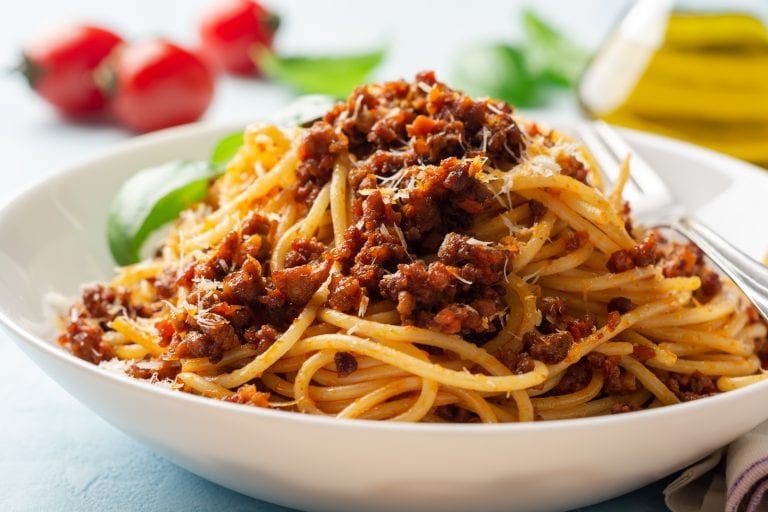 Spaghetti al ragù con pomodorini e basilico in una ciotola