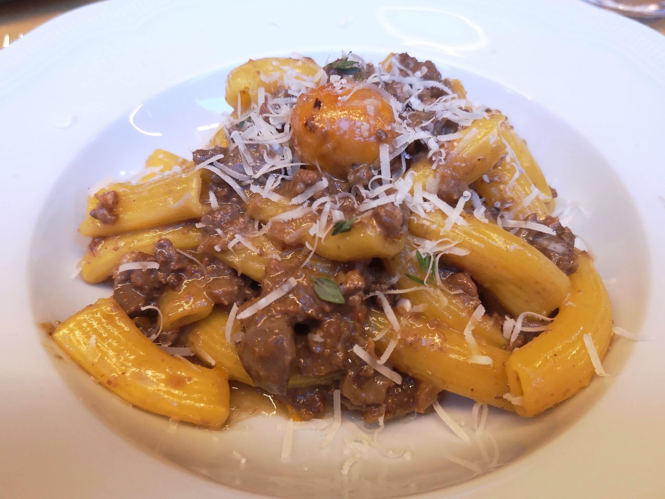 Rigatoni al ragù di cortile con scaglie di parmigiano