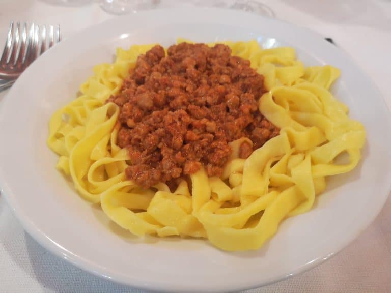 Tagliatelle al ragù su un piatto bianco con la forchetta