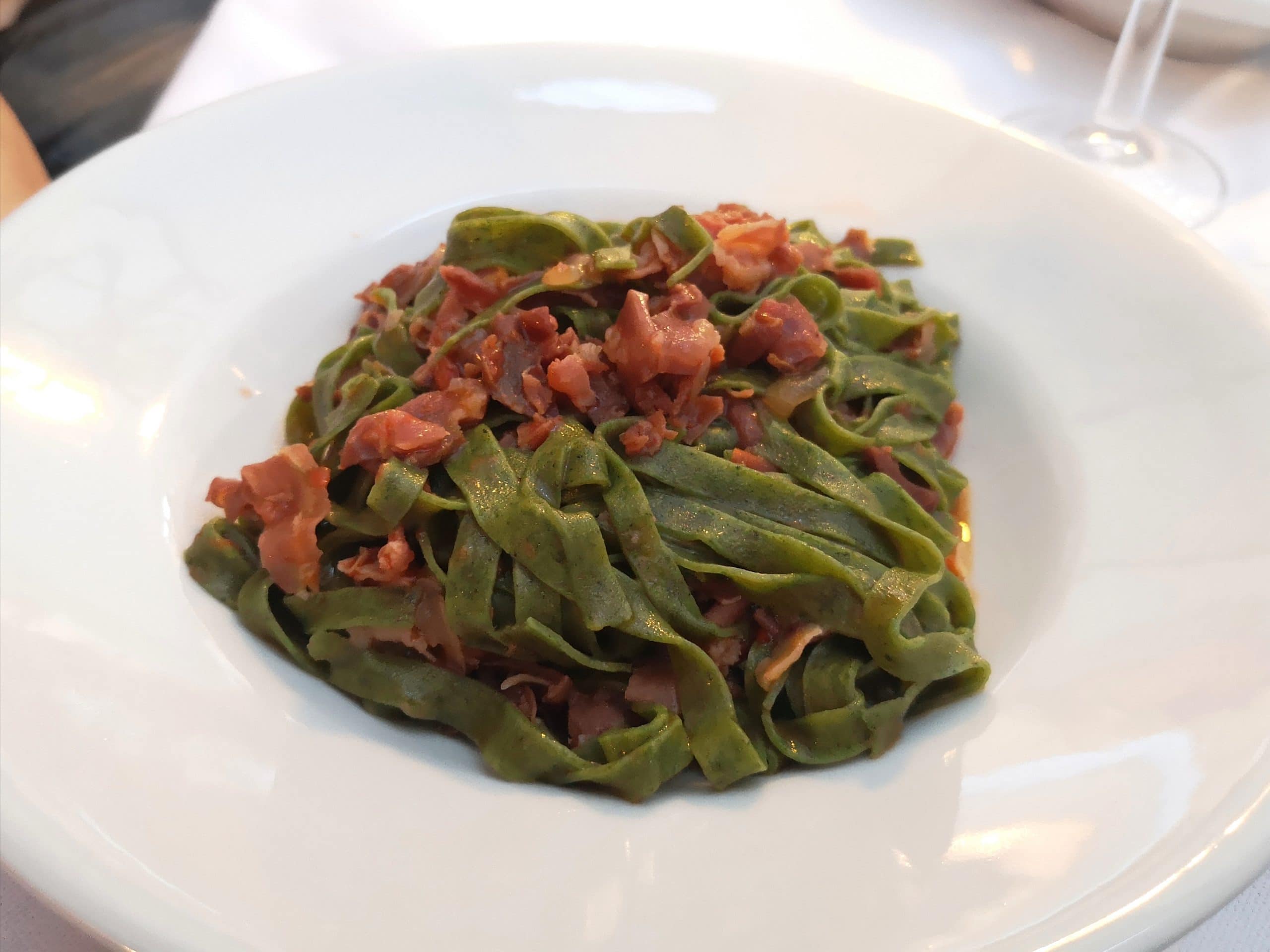 Tagliatelle verdi condite con pancetta croccante a tocchetti