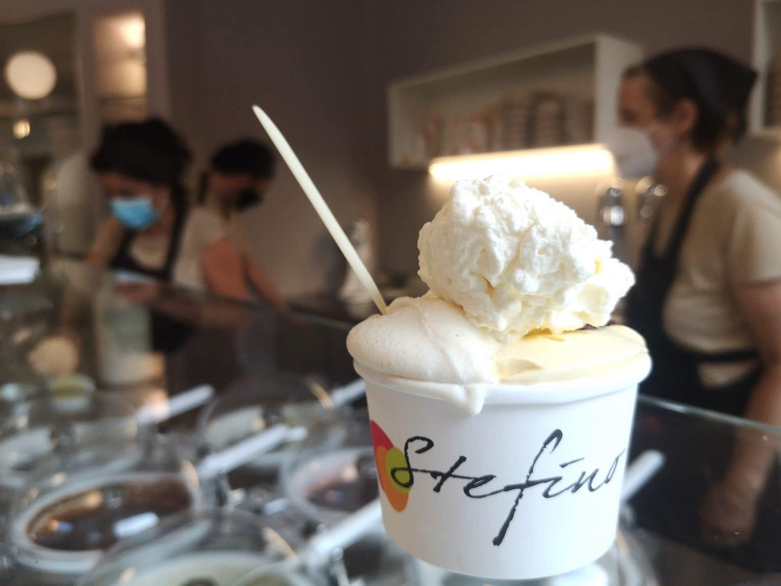 Coppetta di gelato con panna al banco di una gelateria