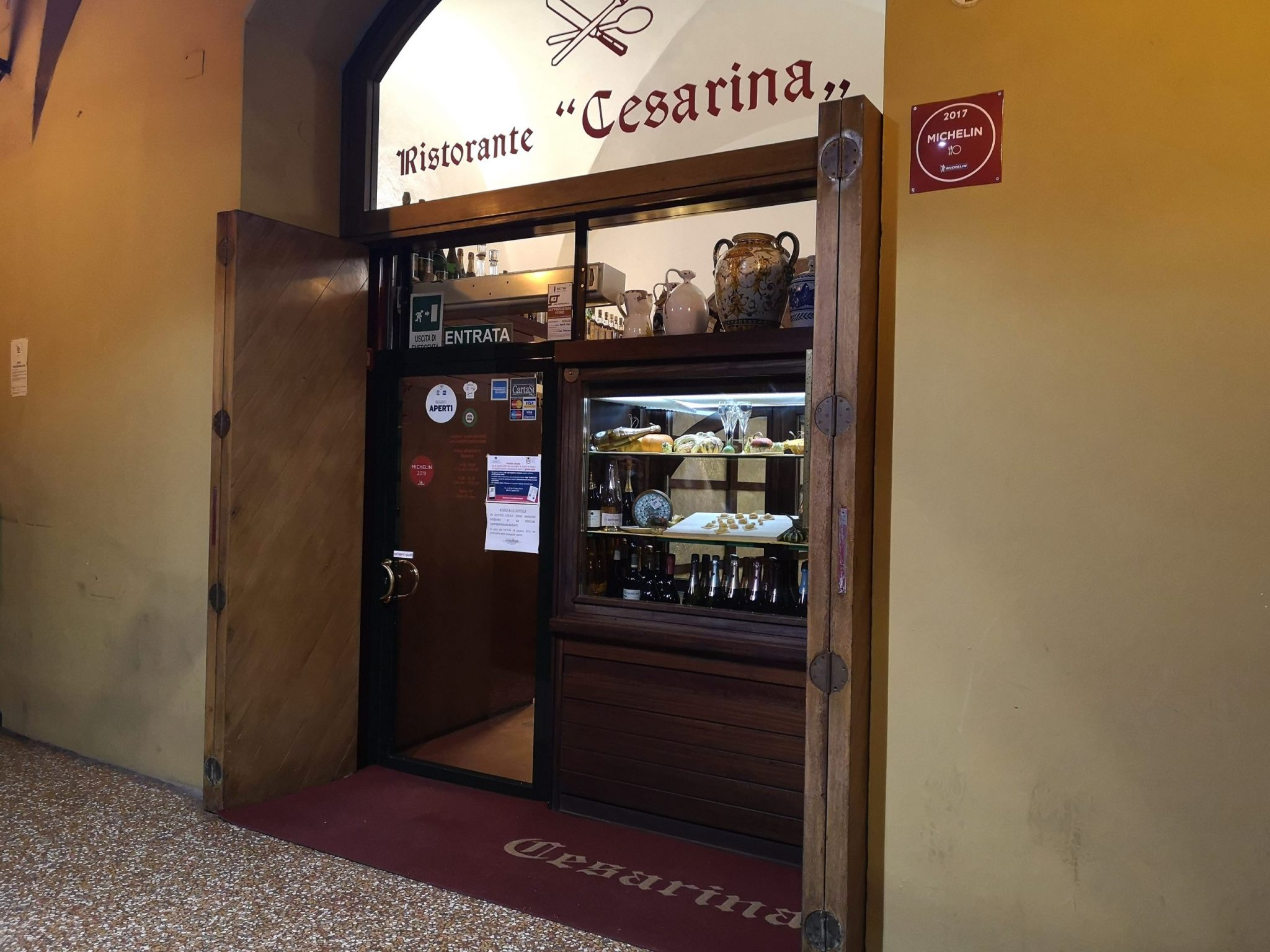 Ingresso del ristorante Cesarina a Bologna con insegna e vetrina